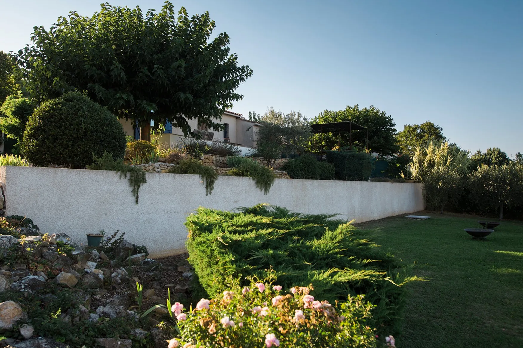Le jardin clos de 1 500 m² et la piscine en contrebas